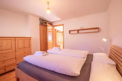 a bedroom with two beds with white sheets at River Valley View House in Bohinjska Bistrica