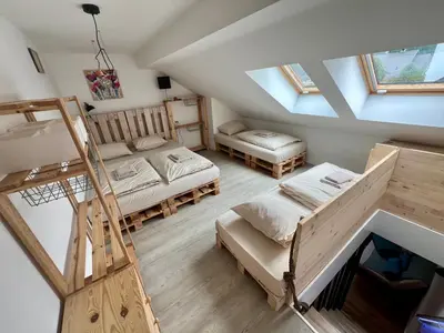 an attic room with two beds and a ladder at Sport & Sunny Cosy Alpine Retreat in Kranjska Gora