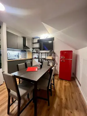 a dining room with a table and a red refrigerator at Sport & Sunny Cosy Alpine Retreat in Kranjska Gora