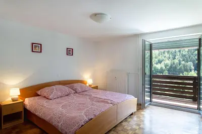 a bedroom with a bed and a large window at Iglica Apartments - First Floor in Bohinjska Bela