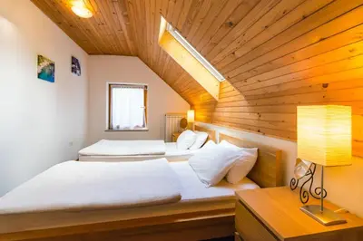 two beds in a room with a wooden ceiling at Lepa Soca House in Čezsoča