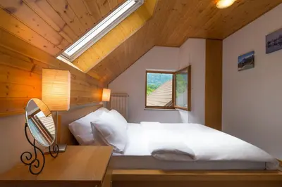a bedroom with a bed with a desk and a window at Lepa Soca House in Čezsoča
