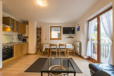 a living room with a table and a kitchen at Lepa Soca House in Čezsoča