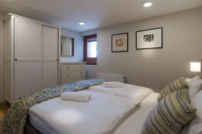 a bedroom with two white beds and a window at Mostnica Cottage in Bohinj