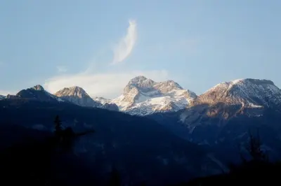 a mountain range with snow covered mountains in the background at Mostnica Cottage in Bohinj