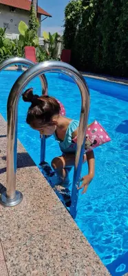 a little girl playing in the water in a pool at APARTMAN MURKO S-1 in Brest
