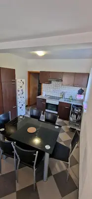 a kitchen with a table and chairs in a kitchen at APARTMAN MURKO S-1 in Brest