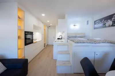 a kitchen with white cabinets and a counter top at Relax Studio Kranjska Gora in Kranjska Gora