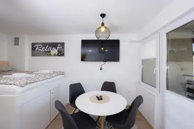 a white dining room with a white table and chairs at Relax Studio Kranjska Gora in Kranjska Gora