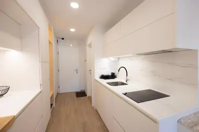 a white kitchen with a sink and a counter at Relax Studio Kranjska Gora in Kranjska Gora