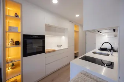 a white kitchen with a sink and a stove at Relax Studio Kranjska Gora in Kranjska Gora