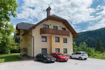a building with three cars parked in a parking lot at Sava View 8 in Ribno