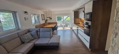 a living room with a couch and a kitchen at Family house Kranjska Gora in Kranjska Gora