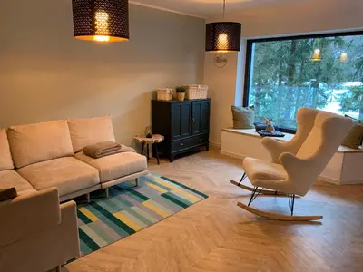 a living room with a couch and a chair at Pine Tree Holiday House in Gozd Martuljek