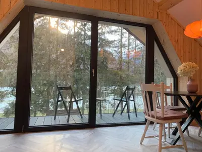 a room with sliding glass doors and a table and chairs at Pine Tree Holiday House in Gozd Martuljek