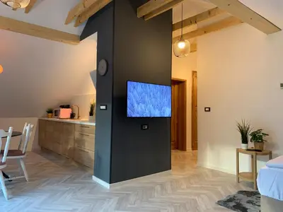 a living room with a tv on a wall at Pine Tree Holiday House in Gozd Martuljek