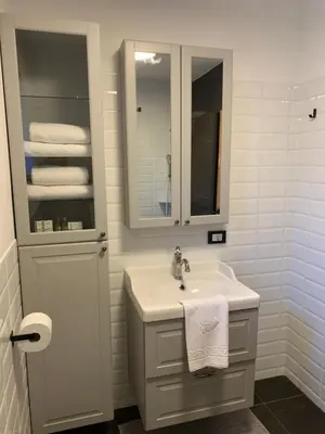 a bathroom with a sink and a mirror and towels at Pine Tree Holiday House in Gozd Martuljek
