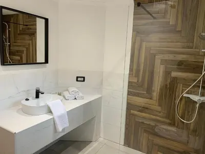 a white bathroom with a sink and a shower at Pine Tree Holiday House in Gozd Martuljek