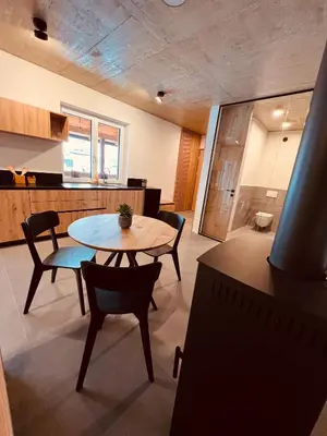 a room with a table and chairs and a kitchen at Holiday House Šmuc in Kranjska Gora