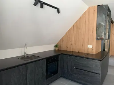 a kitchen with a black counter top and a sink at Holiday House Šmuc in Kranjska Gora