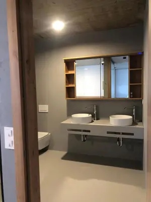 a bathroom with two sinks and a toilet at Holiday House Šmuc in Kranjska Gora