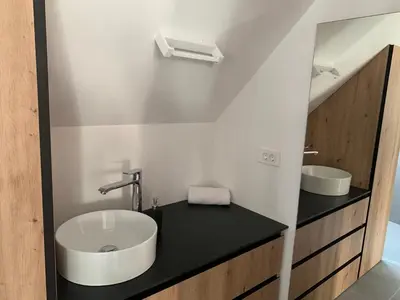 a bathroom with a sink and a mirror at Holiday House Šmuc in Kranjska Gora