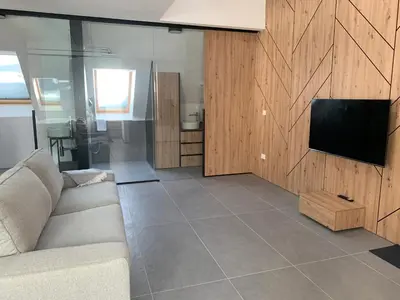 a living room with a couch and a flat screen tv at Holiday House Šmuc in Kranjska Gora