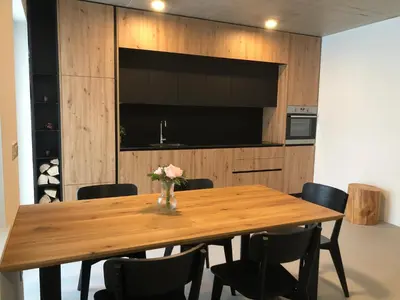 a dining room with a wooden table and chairs at Holiday House Šmuc in Kranjska Gora