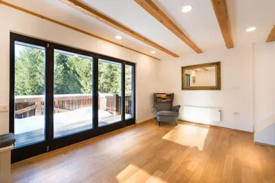 a living room with wooden floors and large windows at Villa Frida in Bohinj