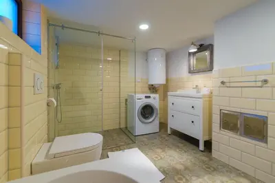 a bathroom with a toilet and a washing machine at Villa Frida in Bohinj