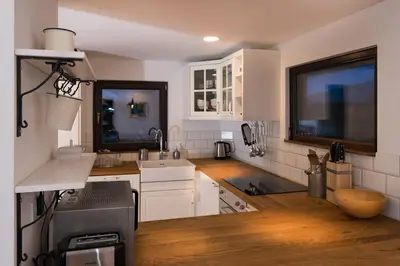 a kitchen with white cabinets and a wooden floor at Villa Frida in Bohinj