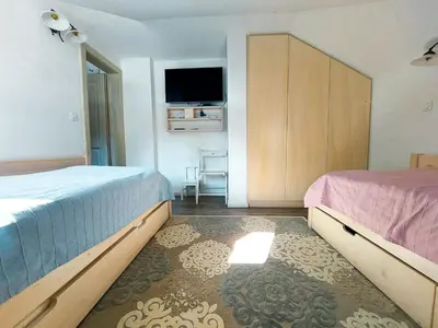 a bedroom with two beds and a flat screen tv at Apartment Soul with Free Parking in Kranjska Gora