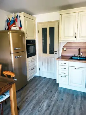 a kitchen with white cabinets and a stainless steel refrigerator at Apartment Soul with Free Parking in Kranjska Gora
