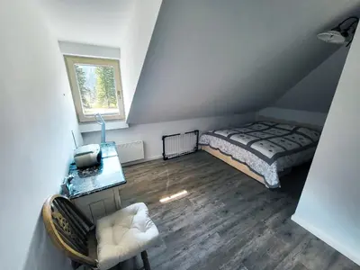 a bedroom with a bed and a desk and a window at Apartment Soul with Free Parking in Kranjska Gora