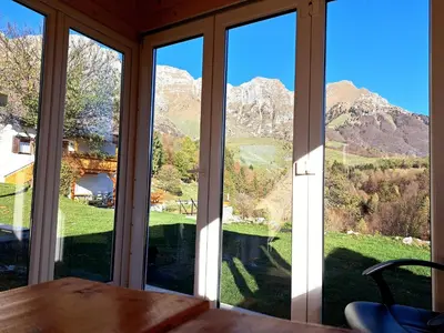 a room with large windows with a view of mountains at Apartma Humar in Kobarid