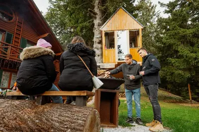 a group of people standing in front of a cabin at Tree House Alpinka Krvavec in Cerklje na Gorenjskem