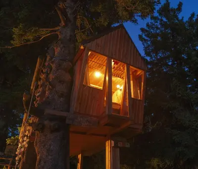 a tree house with a light inside of it at Tree House Alpinka Krvavec in Cerklje na Gorenjskem
