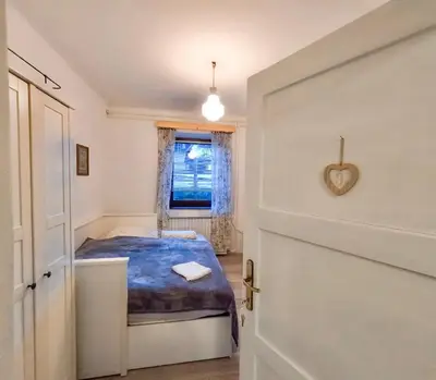 a small bedroom with a bed and a window at Alpine Home - Rooms in Kranjska Gora