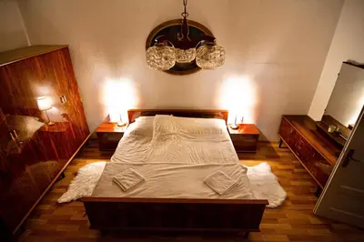 a bedroom with a large bed and a chandelier at Alpine Home - Rooms in Kranjska Gora