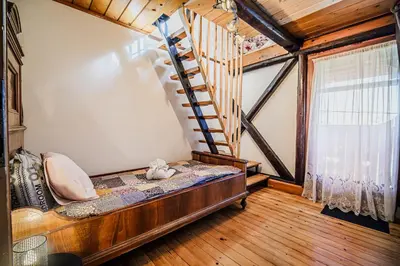 a room with a bed and a staircase in a house at Traditional Slovenian House Pr'Belej in Zgornje Gorje