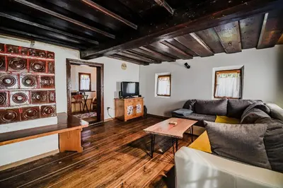 a living room with a couch and a tv at Traditional Slovenian House Pr'Belej in Zgornje Gorje