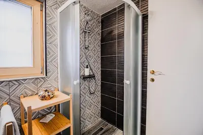 a bathroom with a shower and a wooden table at Traditional Slovenian House Pr'Belej in Zgornje Gorje