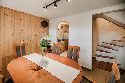 a dining room table with a vase of flowers on it at Traditional Slovenian House Pr'Belej in Zgornje Gorje
