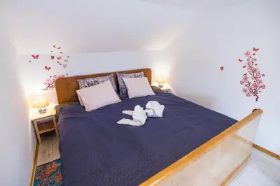 two stuffed animals are sitting on a bed at Traditional Slovenian House Pr'Belej in Zgornje Gorje