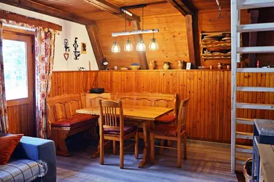 a wooden dining room with a wooden table and chairs at Hiša Pr Valter in Jesenice