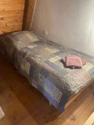a bed with a quilt on top of it at Hiša Pr Valter in Jesenice