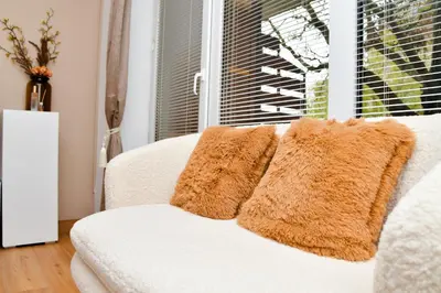 a white couch with two brown pillows on it at Miadora apartments - Apartma Idina in Moravske Toplice