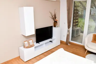 a white living room with a flat screen tv at Miadora apartments - Apartma Idina in Moravske Toplice