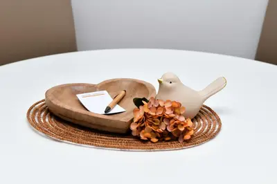 a table topped with a bird figurine and a plate at Miadora apartments - Apartma Idina in Moravske Toplice