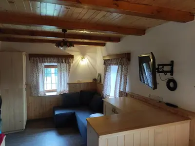 a living room with a blue couch and windows at Apartma Hodnik Bohinj Uskovnica in Srednja Vas v Bohinju